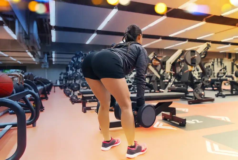 kobieta trenująca pośladki z hantlami