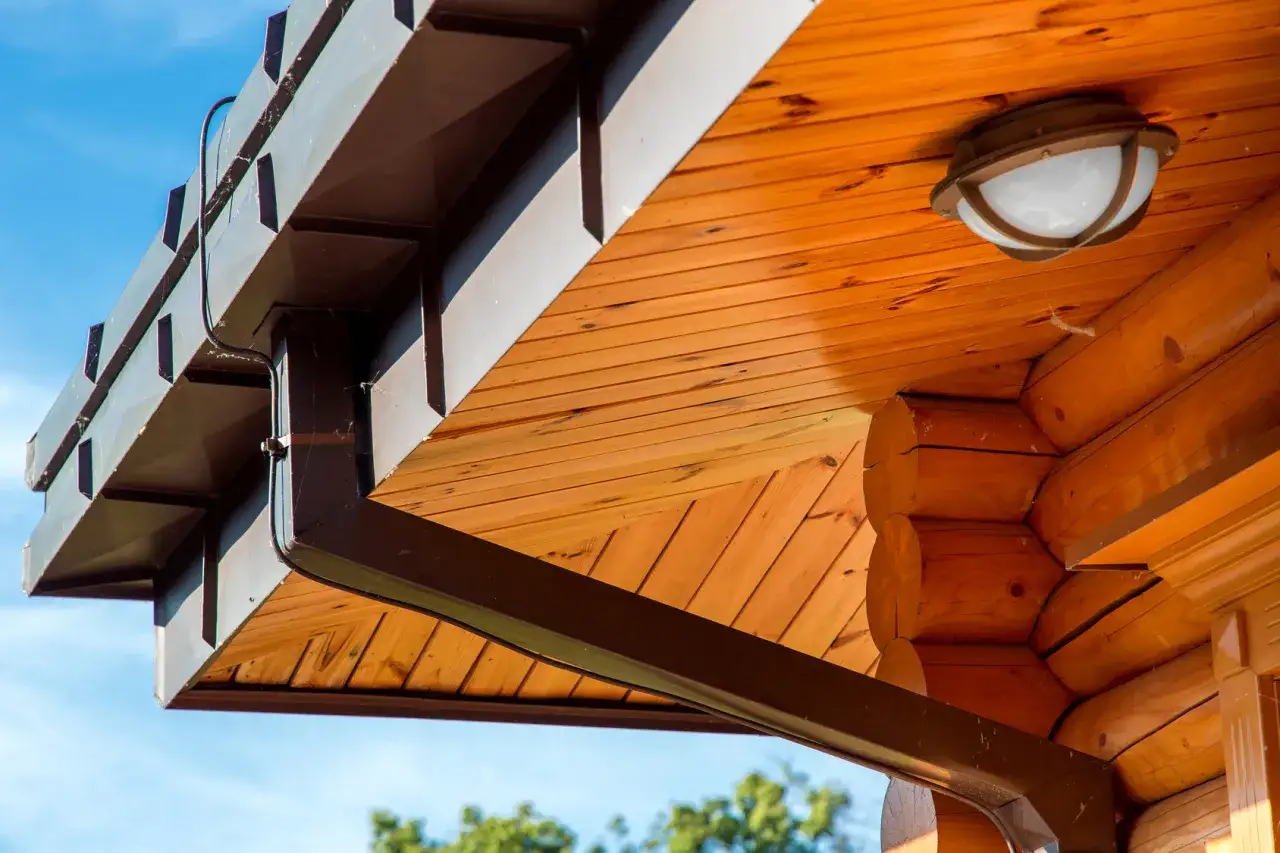 Oświetlenie zewnętrzne: jak zamontować lampki pod dachem drewnianego domu, obok rynny.