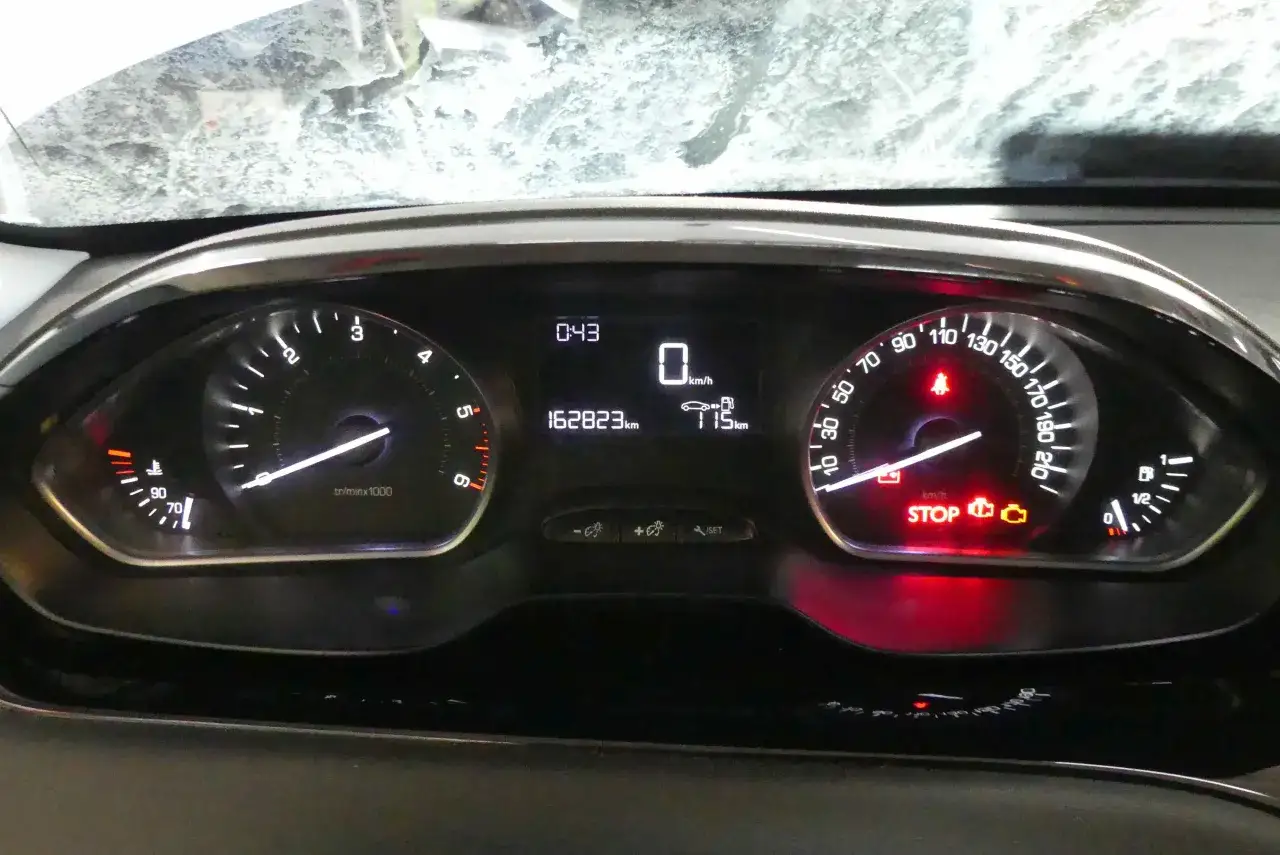 Deska rozdzielcza Peugeot 208 pokazuje niski poziom paliwa, co sugeruje, że pojemność baku jest bliska wyczerpania.
