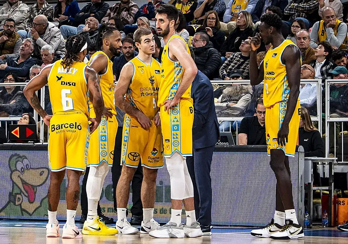 Jugadores del club baloncesto Gran Canaria en la cancha, con sus uniformes amarillos y detalles azules.