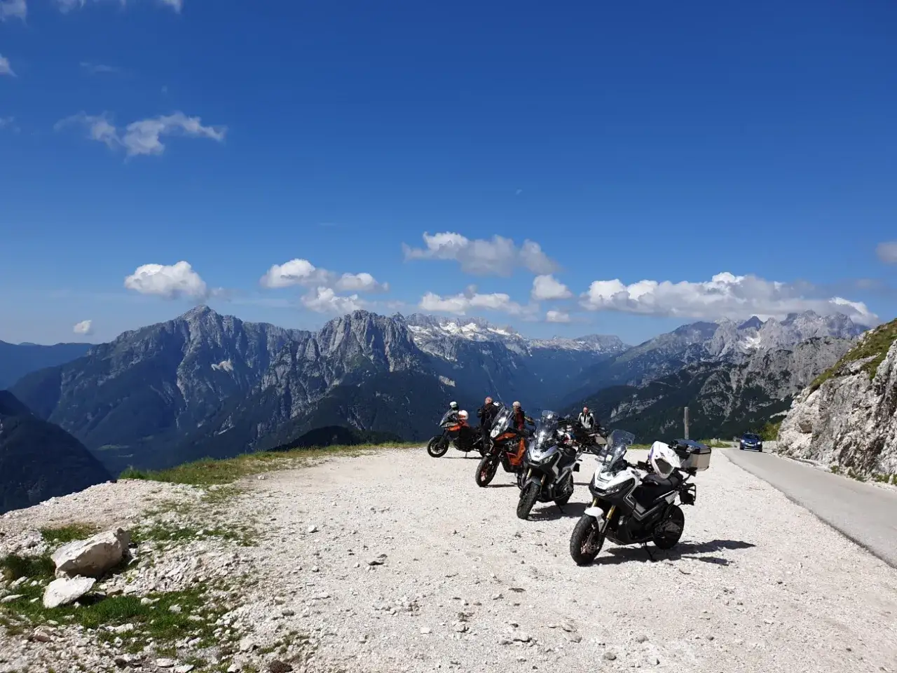 Grupa motocyklist&oacute;w odpoczywa na tle majestatycznych g&oacute;r, ciesząc się pięknymi trasami motocyklowymi w Austrii.