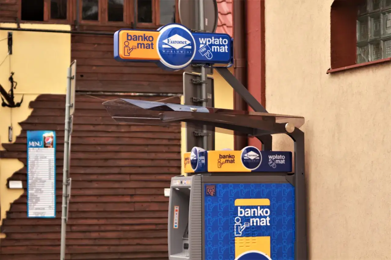 Santander bankomat Euronet, zlokalizowany przy drewnianej elewacji. Wpłatomat oferuje szybkie transakcje.