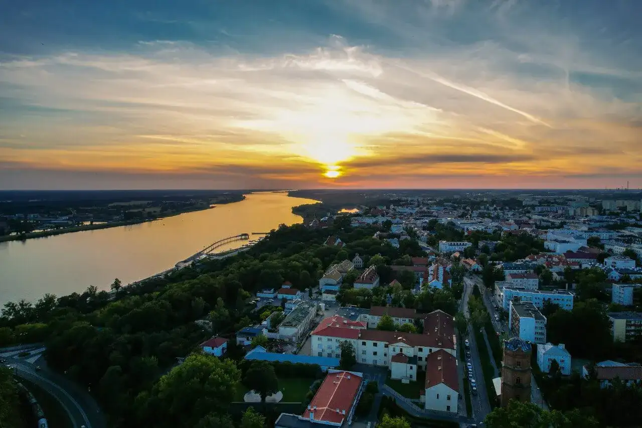 Zachód słońca nad Wisłą i miastem. Warto zobaczyć w Płocku malowniczą panoramę z górującym zamkiem i katedrą.