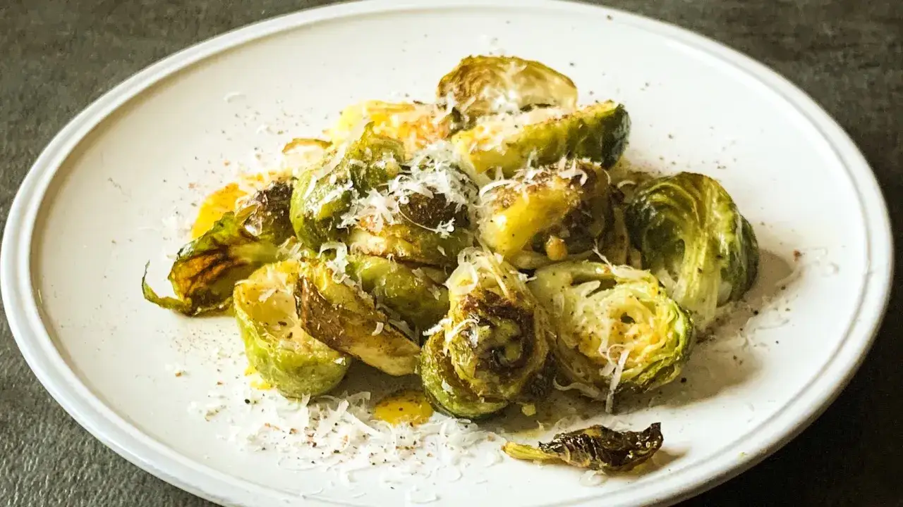 Pyszna sałatka z brukselką, pieczona do perfekcji, posypana parmezanem i skropiona oliwą.