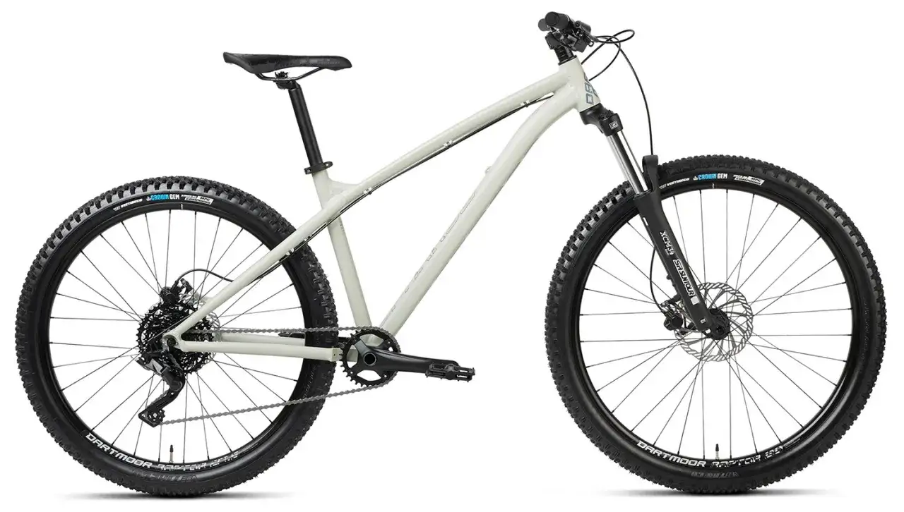 Jasny, szary rower górski z grubymi oponami i amortyzatorem – idealny rower na singletrack.