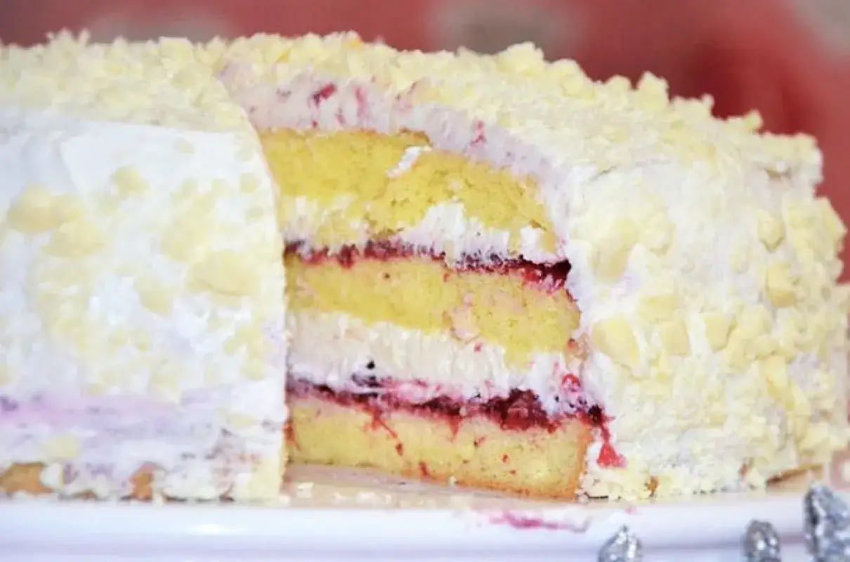 Puszysty biszkopt przełożony kremem i malinami, oblany białą czekoladą. Idealny pomysł, co zrobić z serka mascarpone na specjalną okazję.