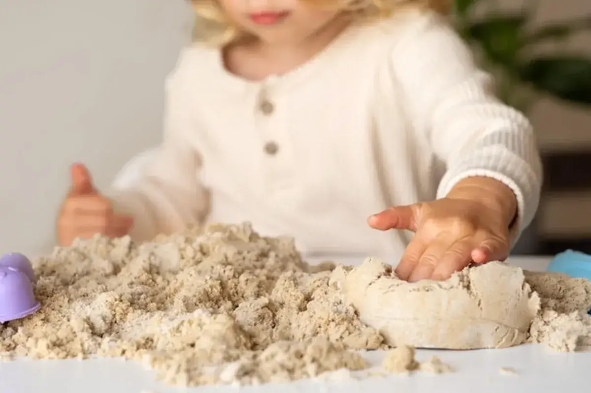 dziecko bawi się domowym piaskiem kinetycznym z mąki