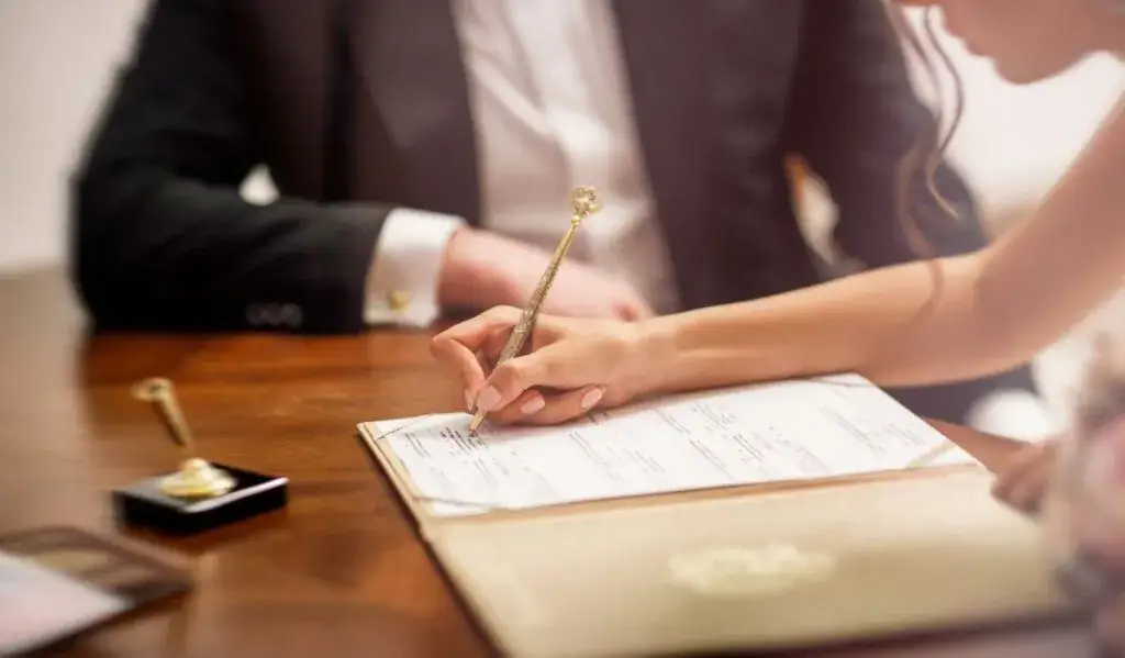 para młoda podpisująca dokumenty w USC