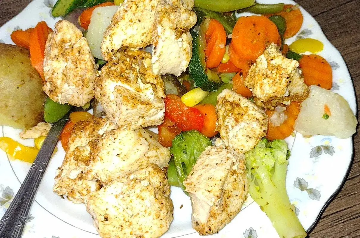 Kawałki kurczaka z przyprawami i kolorowe warzywa, idealne danie, co można ugotować na parze.