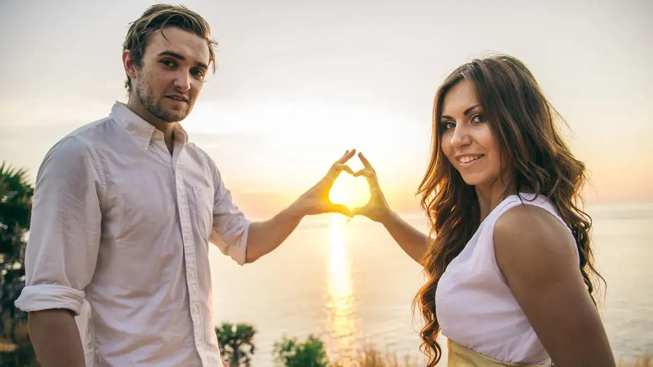 Para wzbudzić w nim tęsknotę, tworzy serce ze słońca zachodzącego nad morzem.