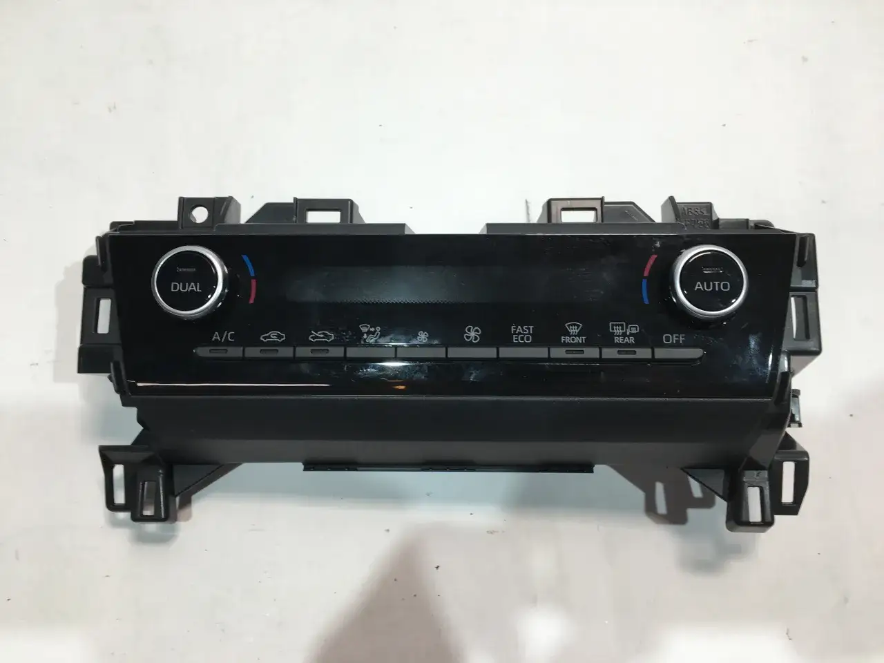 Panel klimatyzacji Toyota Yaris. Jak włączyć chłodzenie? Widoczne przyciski A/C, DUAL, AUTO, FAST, ECO, FRONT, REAR, OFF.