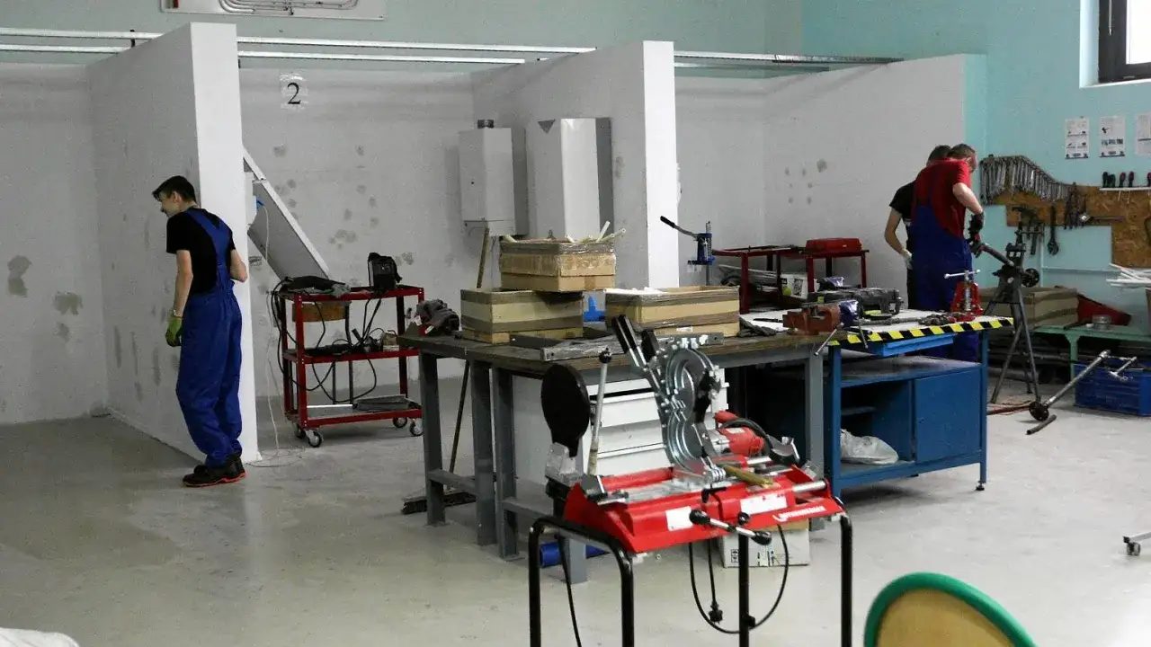 Młodzi ludzie uczący się zawodu hydraulika w szkole branżowej
