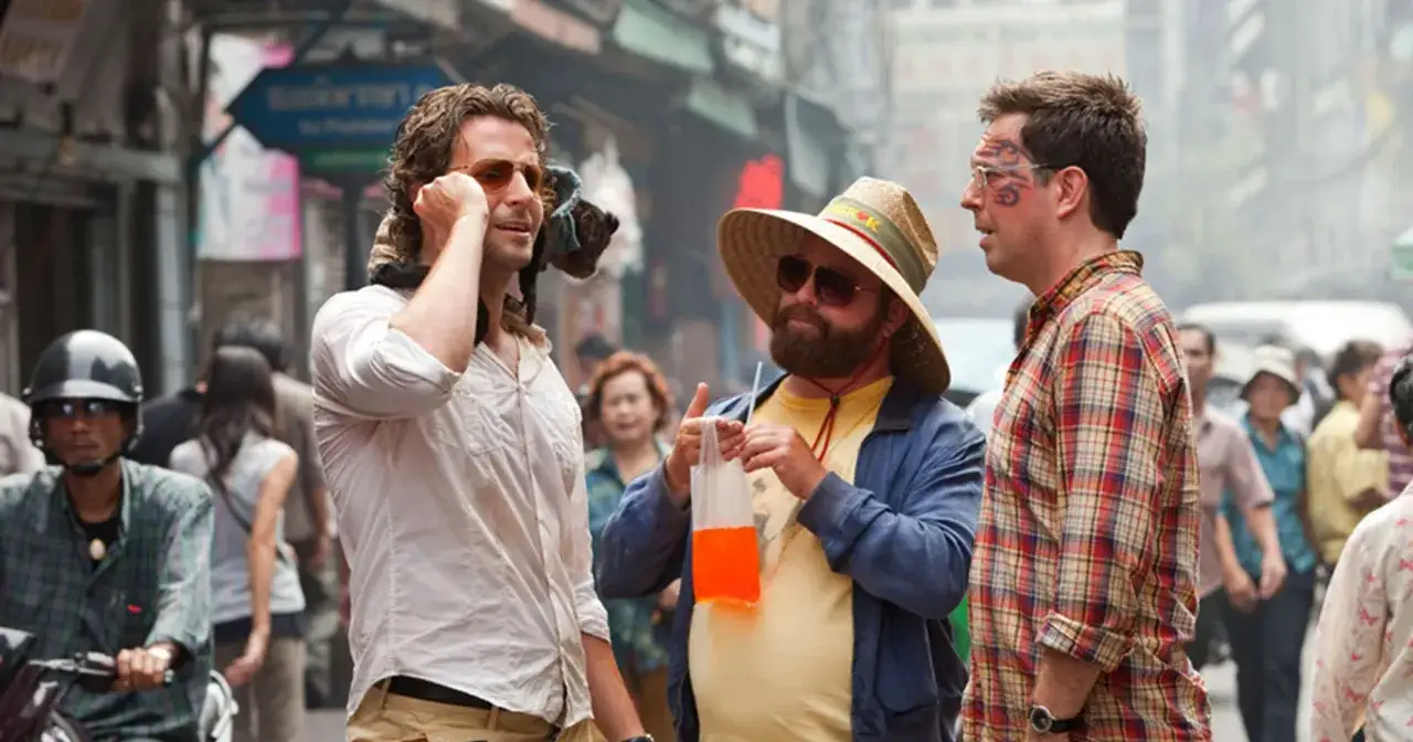 Kac Vegas obsada: Bradley Cooper, Ed Helms i Zach Galifianakis w ulicznej scenie.