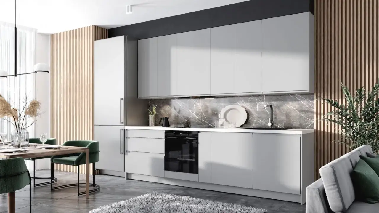 Nowoczesna kuchnia z szarymi meblami, marmurowym blatem i dekoracyjnymi lamelami w tle. Przy stole z zielonymi krzesłami stoi wazon z trawami.