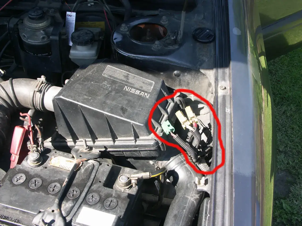 Uszkodzony przekaźnik świec żarowych objawy: widoczne złącza elektryczne w czerwonym okręgu, mogą wskazywać na problem z rozruchem silnika diesla.