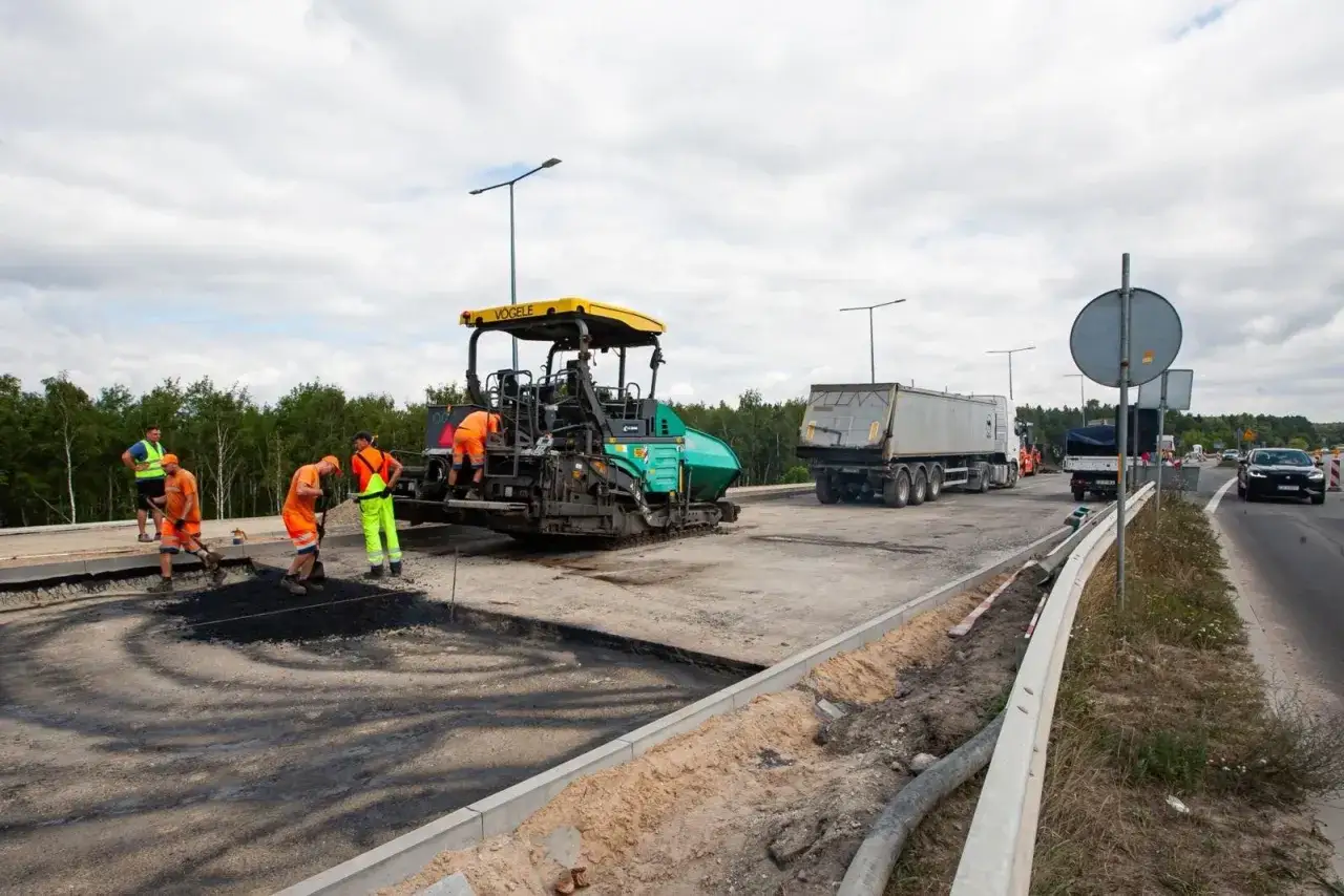 Pracownicy układają asfalt przy użyciu walca drogowego. Zastanawiasz się, ile kosztuje 1m2 asfaltu?