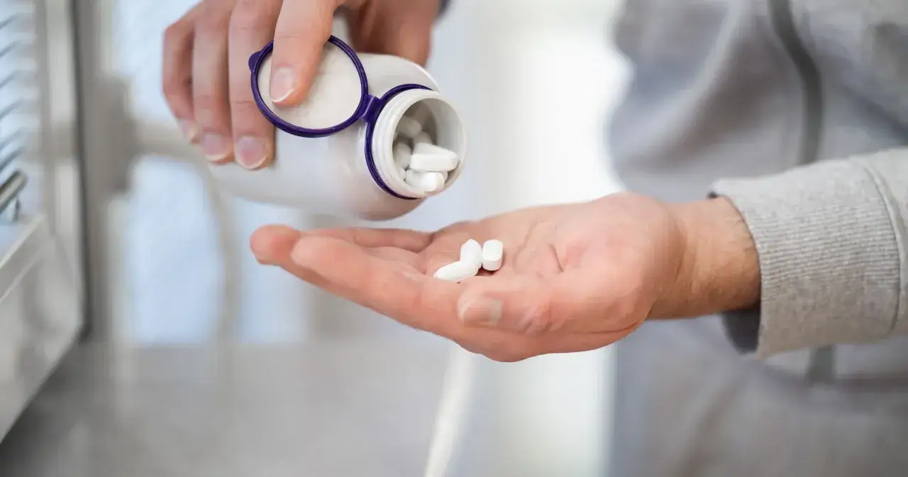 Dłoń z tabletkami magnezu. Z czym nie łączyć magnezu, by uniknąć interakcji i zapewnić jego lepsze wchłanianie.