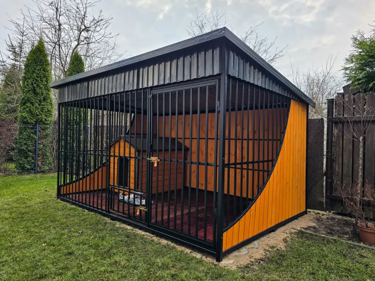 Drewniana podłoga w kojcu dla psa zapewnia ciepło i komfort. Idealne rozwiązanie, czym wyłożyć kojec dla psa, by był przytulny.