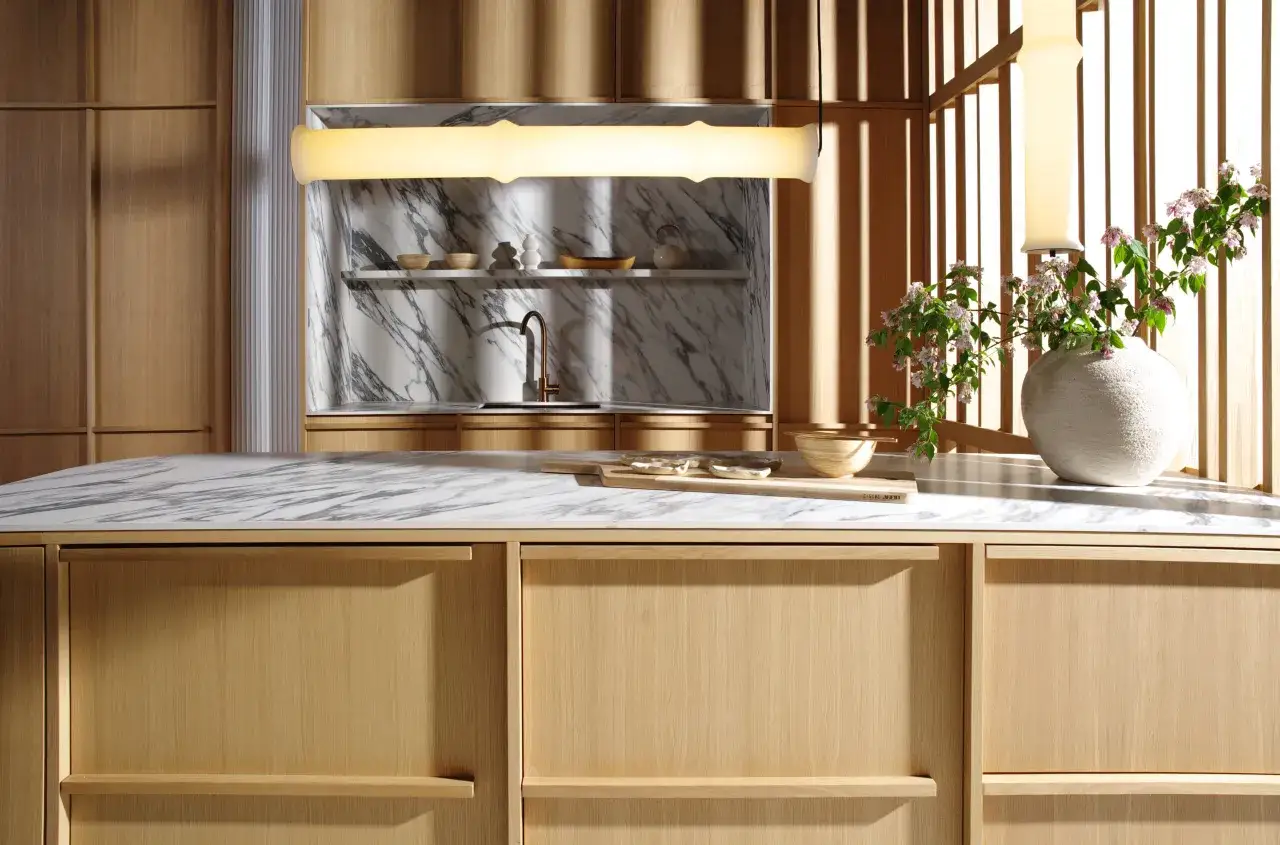 Minimalistyczna styl japandi kuchnia z drewnianymi frontami, marmurowym blatem i subtelnymi dodatkami.