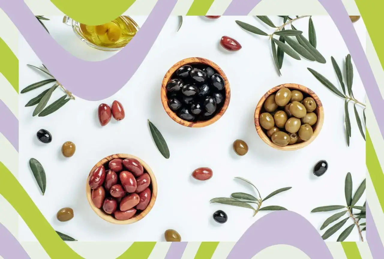 Różne rodzaje oliwek w miseczkach i luźno, gałązki oliwne. Czy oliwki są lekkostrawne? Zależy od sposobu przygotowania.
