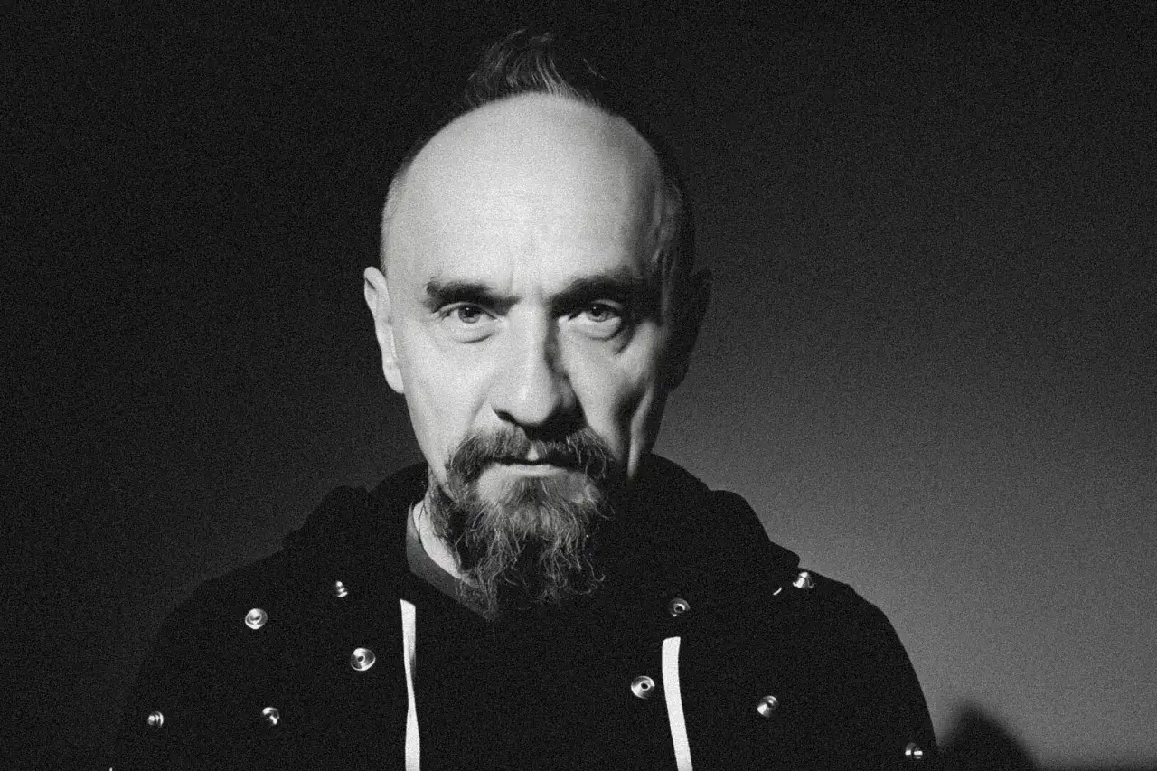 Jan Klata, reżyser znany z odważnych spektakli, z charakterystycznym irokezem i brodą, patrzy prosto w obiektyw.