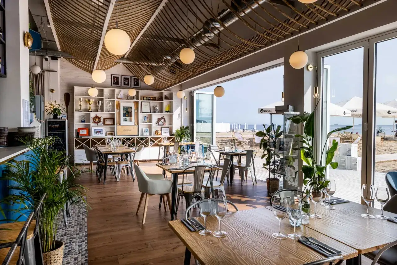 Wnętrze restauracji z widokiem na plażę, idealne miejsce na odkrycie najlepszych restauracji w Sopocie.