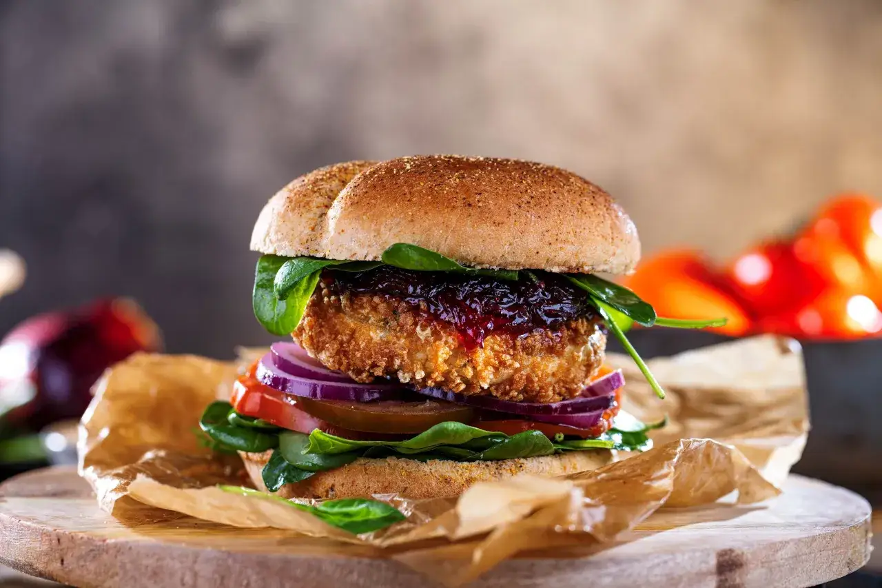 Burger drwala z chrupiącym kotletem, szpinakiem, pomidorem i czerwoną cebulą. Idealny ser do burgera drwala to taki, kt&oacute;ry się dobrze topi.
