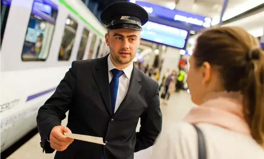 konduktor w pociągu sprzedaje bilet