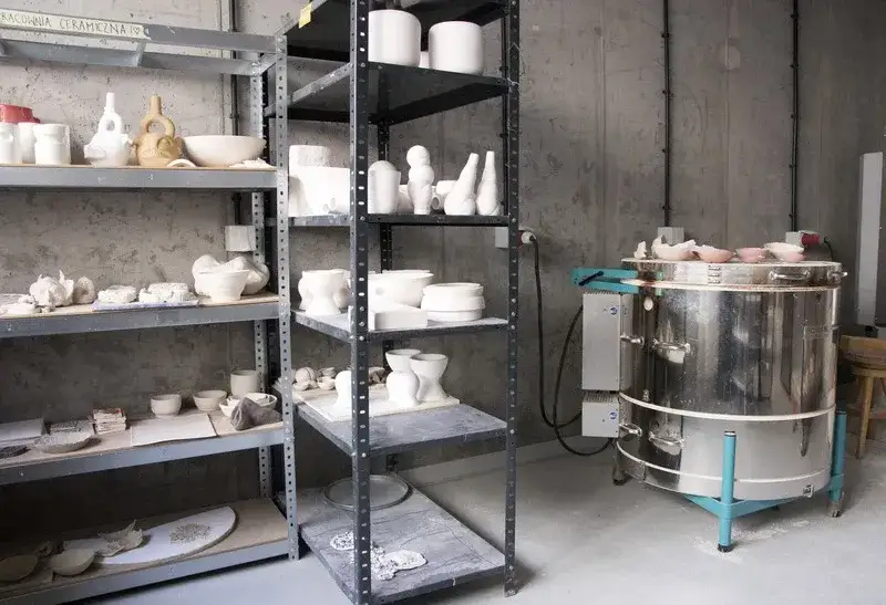 wnętrze pracowni ceramicznej z półkami pełnymi glinianych naczyń
