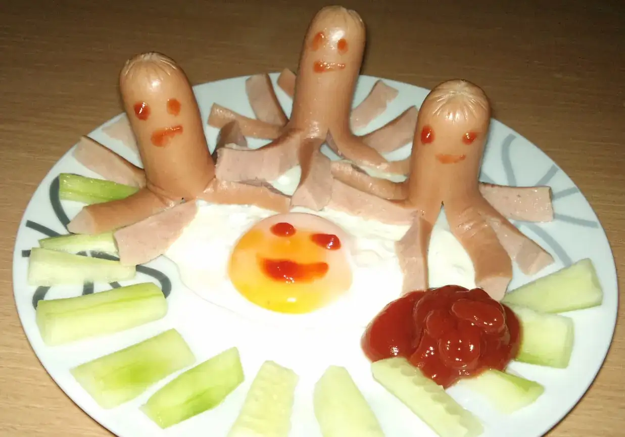 Wesołe parówki-ośmiorniczki i jajko-buzia na talerzu. Idealne śniadanie dla 2 latka, które zachęci do jedzenia.