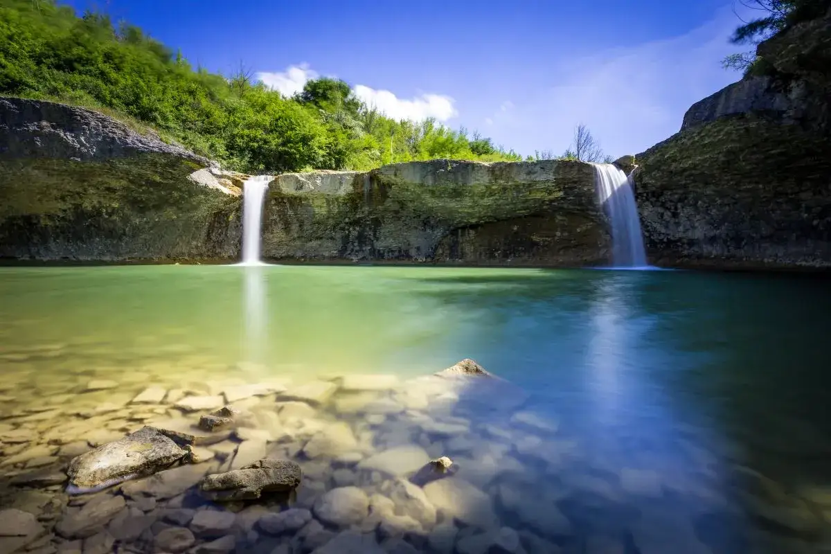 Malownicze wodospady na Istrii tworzą kaskady spadające do turkusowej wody. Kamienie na dnie są widoczne w krystalicznie czystej toni.