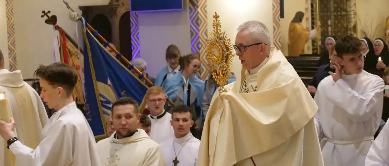 Procesja w bazylice. Ksiądz niesie monstrancję, towarzyszą mu ministranci i wierni. Odeszli do Pana.