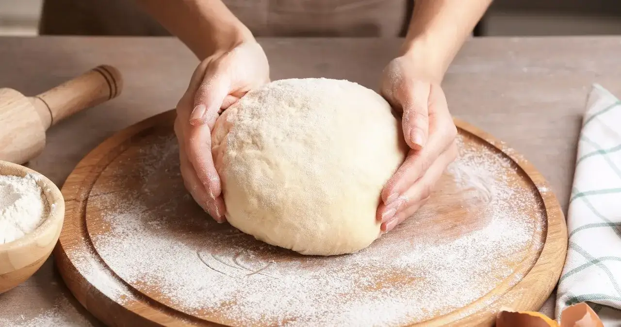 kuchnia z ciastem drożdżowym, ręce wyrabiające ciasto