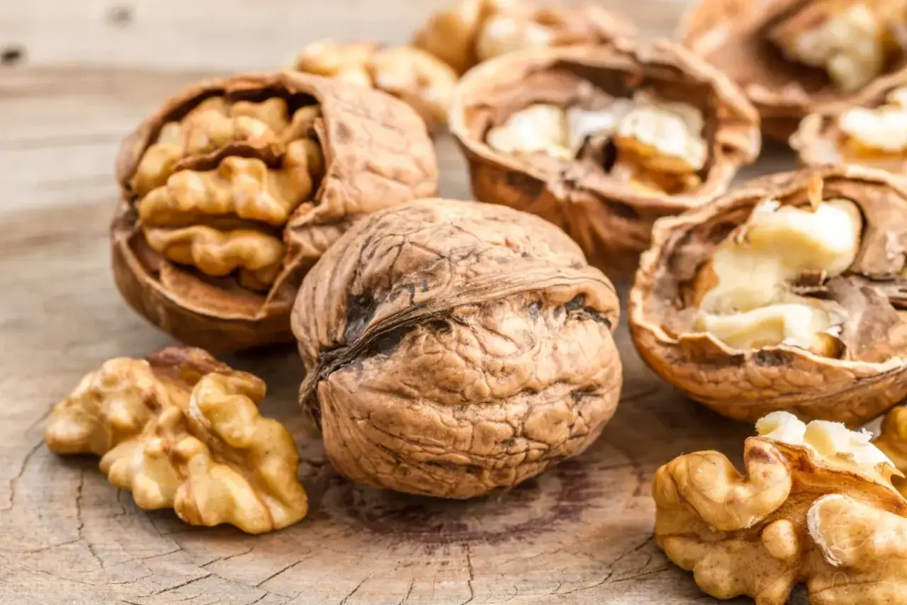 Orzechy włoskie na drewnianym blacie. Czy orzechy włoskie można mrozić? Tak, można je mrozić, by zachować świeżość.