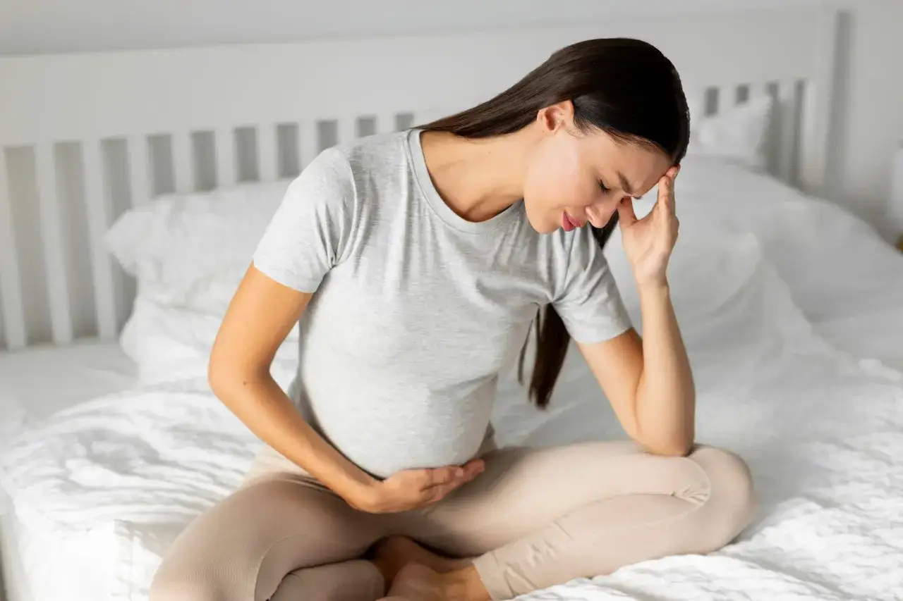 Kobieta w ciąży z bólem głowy, zastanawia się, czy nospa w ciąży jest bezpieczna.