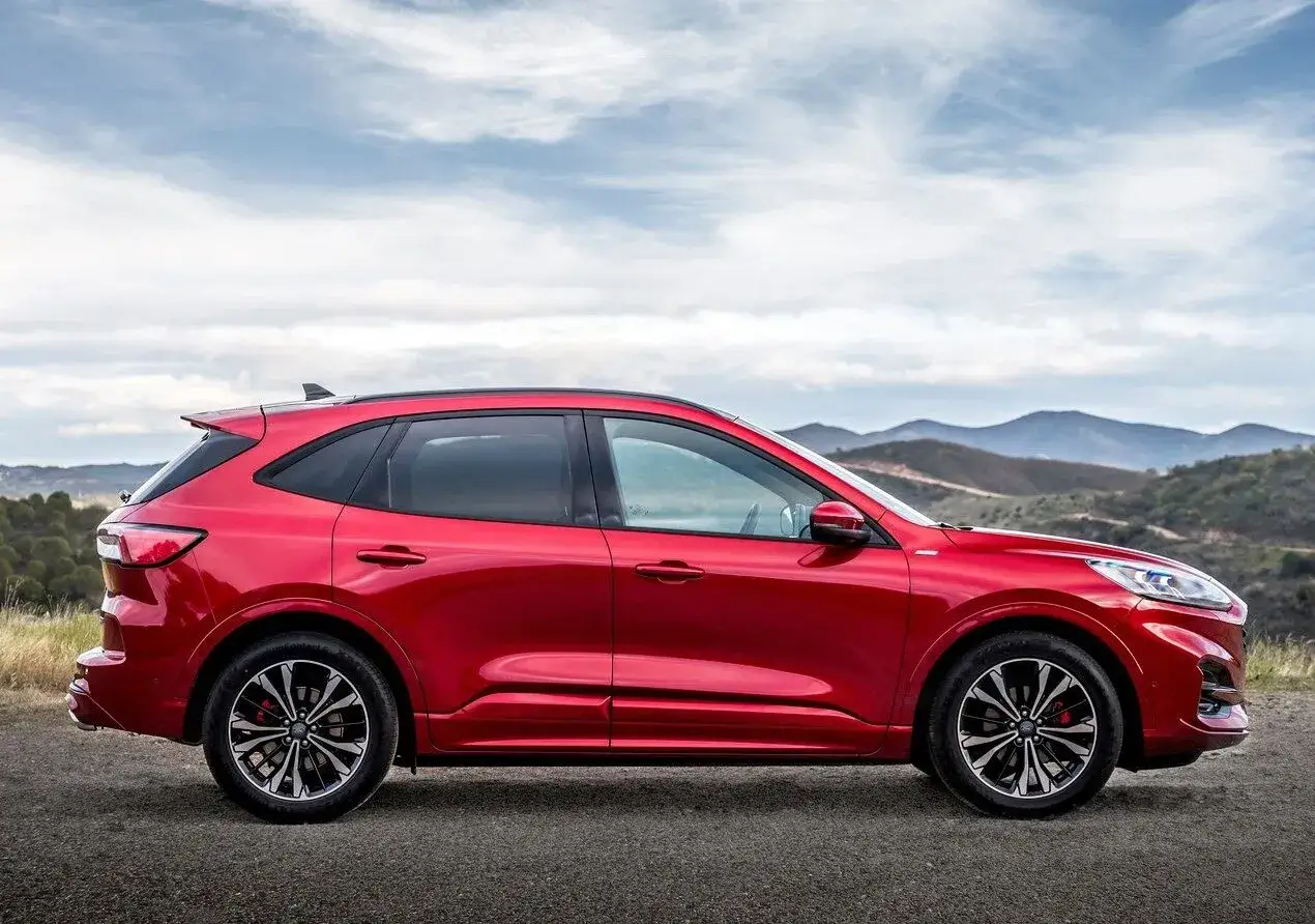 Czerwony Ford Kuga na tle górskich krajobrazów. Zobacz, jak jego wymiary prezentują się w otwartej przestrzeni.
