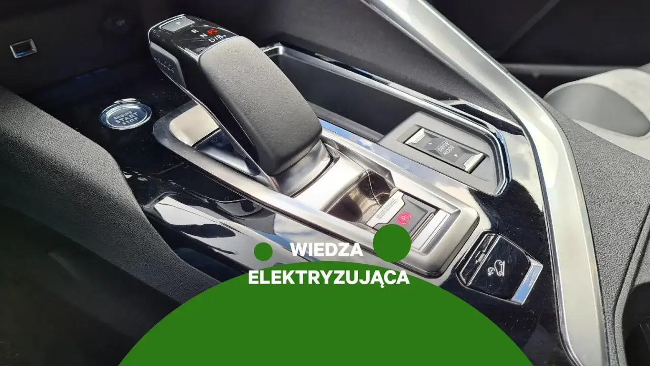 Dźwignia skrzyni automatycznej z oznaczeniami P, R, N, D/B. Obok przycisk Start/Stop i hamulec postojowy.