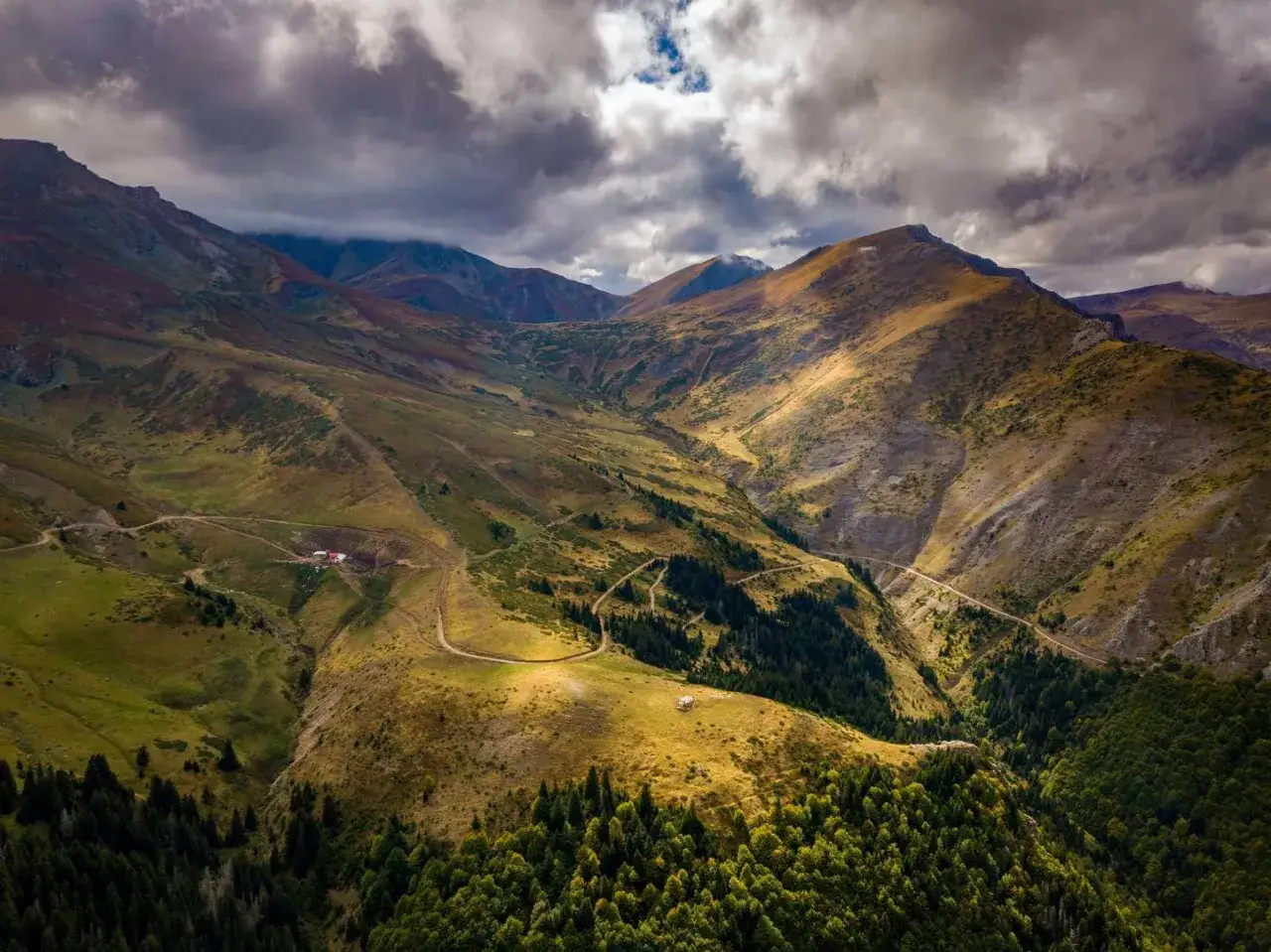 Malownicze macedonia g&oacute;ry jesienią. Słoneczne zbocza przeplatają się z cienistymi lasami, a kręte drogi prowadzą do ukrytych domk&oacute;w.