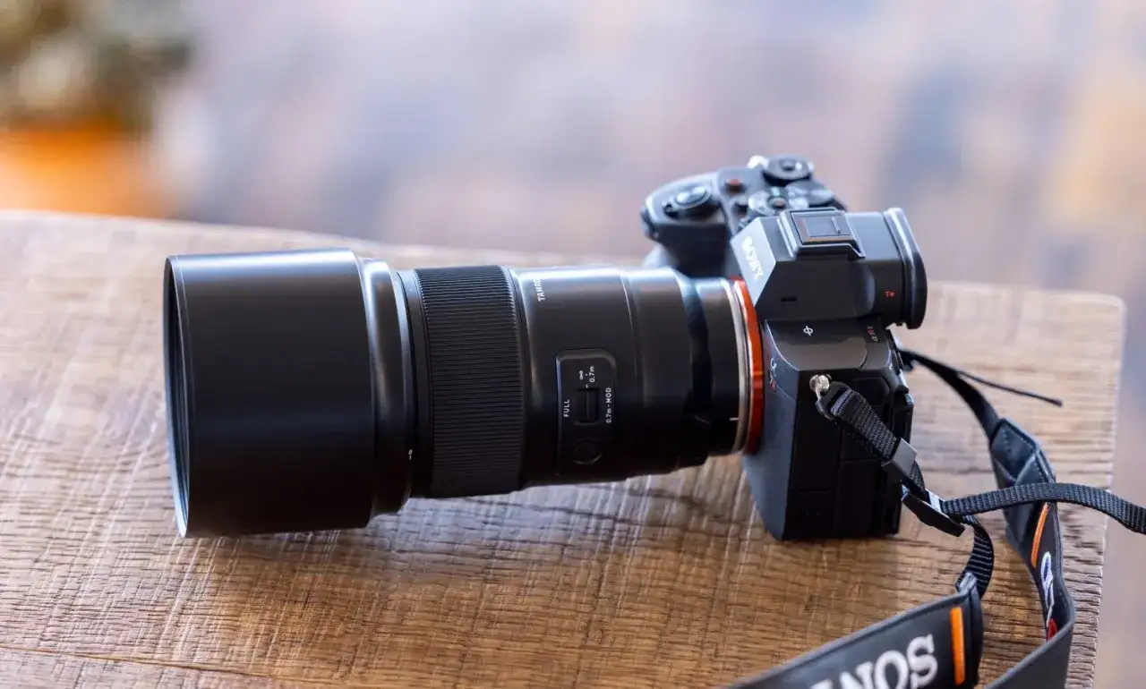 Obiektyw Tamron z przełącznikiem odległości minimalnej, idealny do zdjęć z bliska. Aparat Sony z paskiem na szyję.