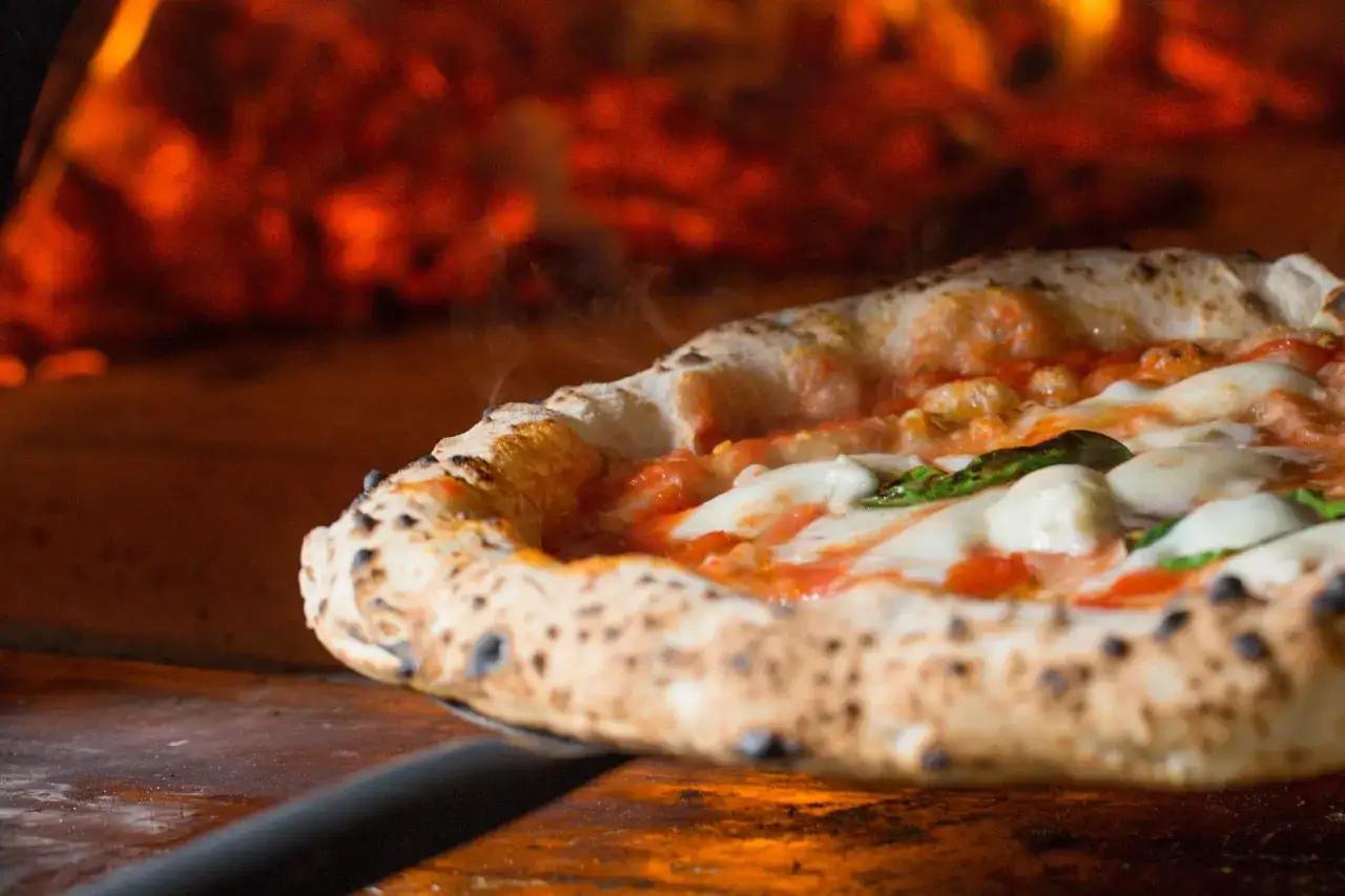 Gorąca pizza prosto z pieca, przypominająca o tym, skąd pochodzi pizza &ndash; z Neapolu.