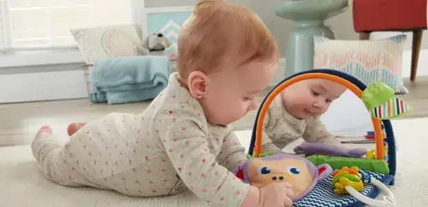 niemowlę 5 miesięcy bawi się zabawkami