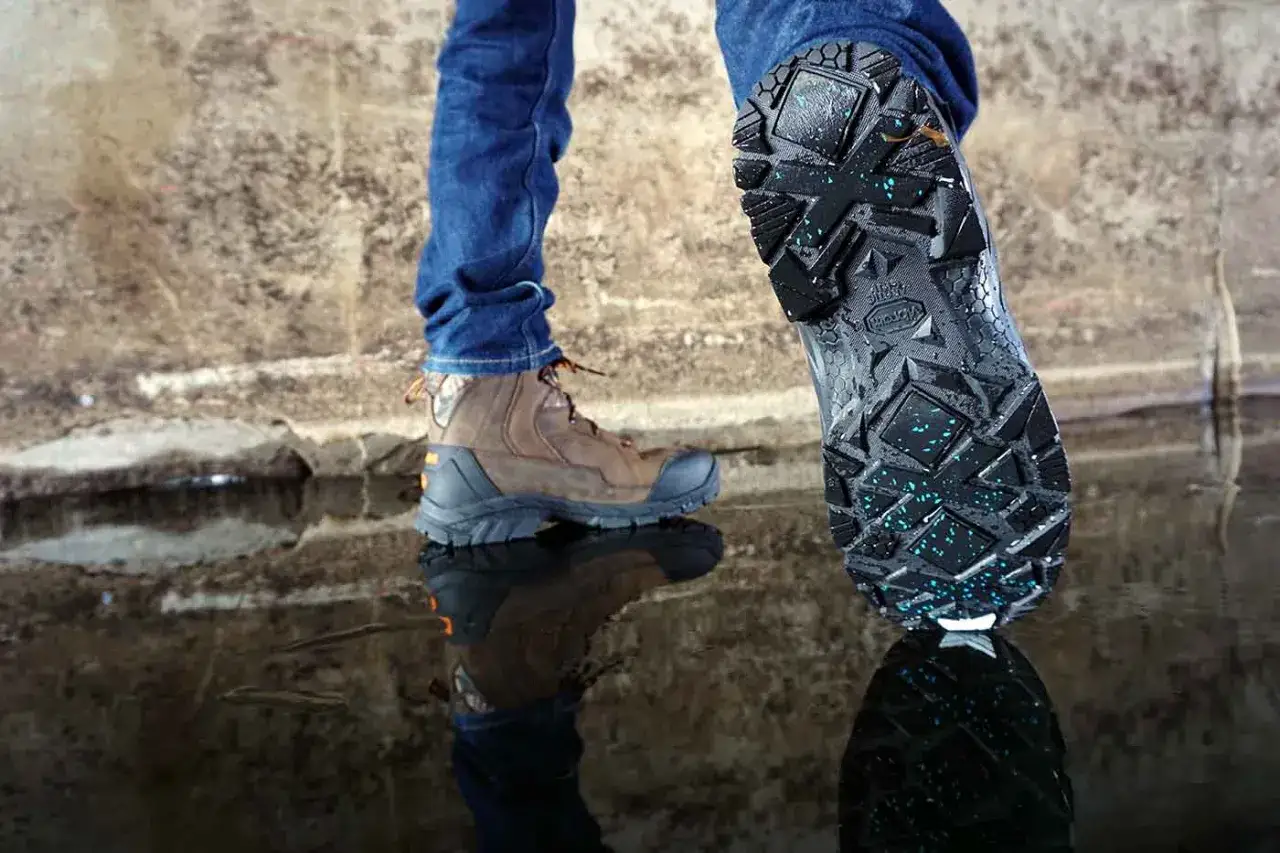 Buty zimowe z agresywnym bieżnikiem i niebieskimi wstawkami antypoślizgowymi. Podeszwy Vibram zapewniają pewność kroku na śliskiej nawierzchni.