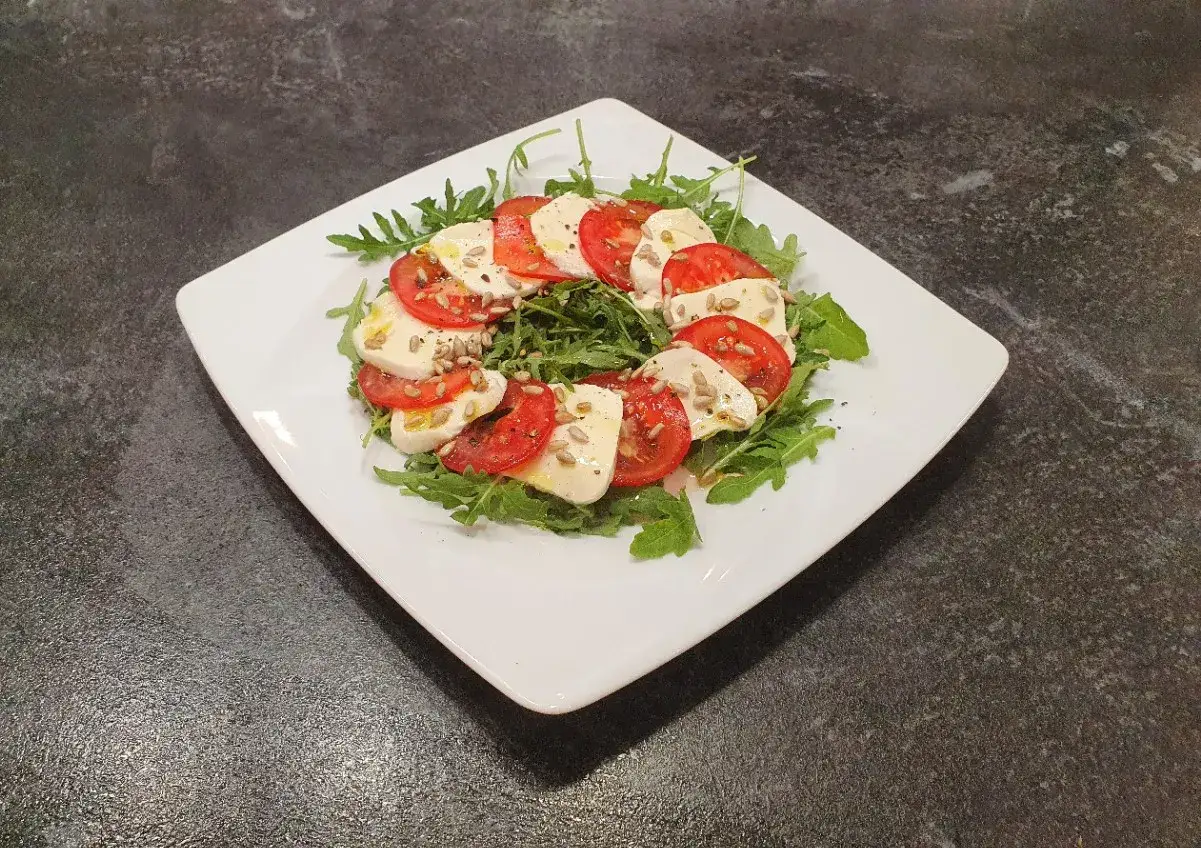 Sałatka caprese z rukolą, pomidorami i mozzarellą. Czy ser mozzarella jest dobry na odchudzanie? To lekkie danie, idealne na dietę.