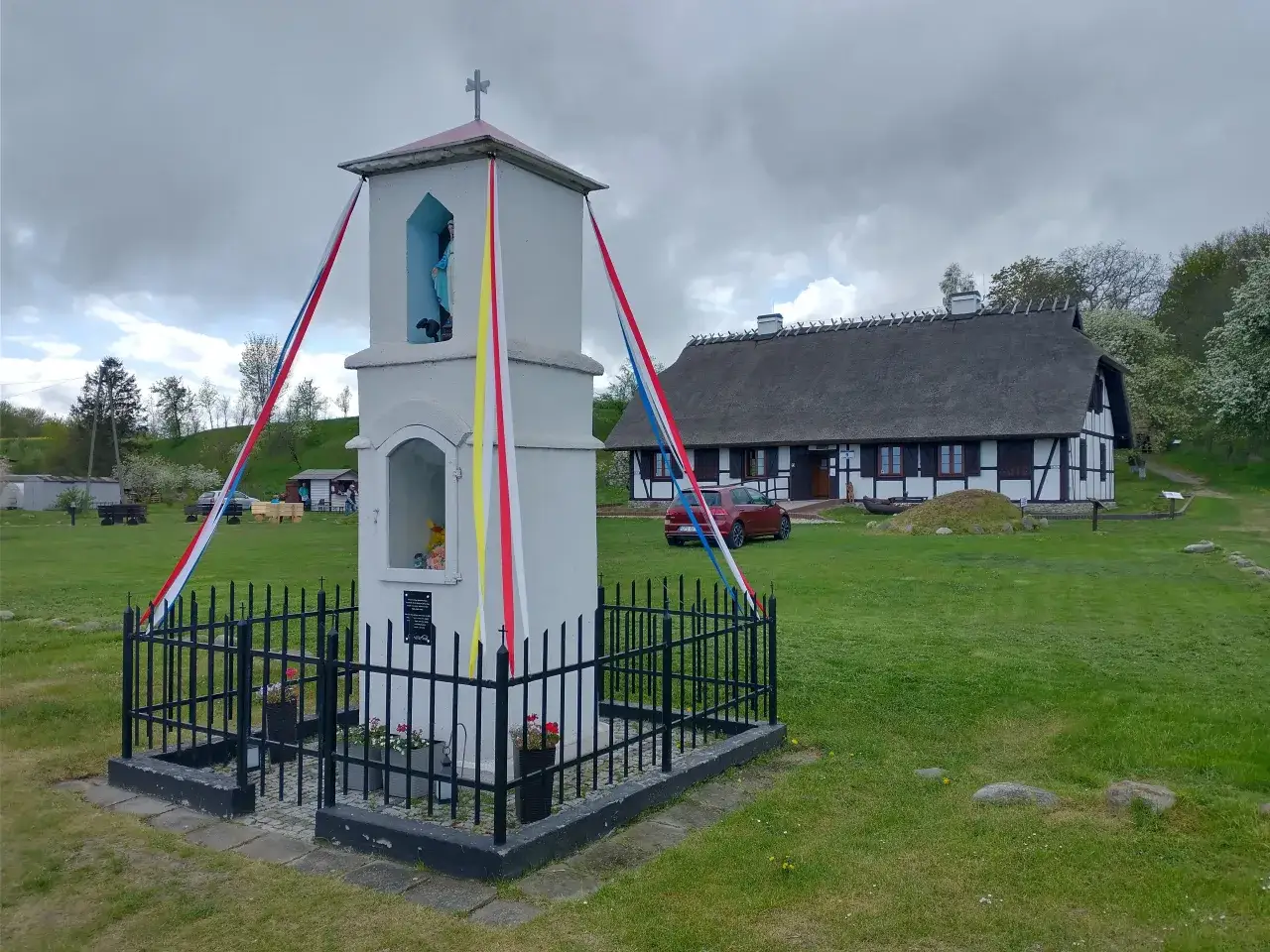 Kapliczka i tradycyjny dom z trzcinowym dachem w parku kulturowym osada łowców fok w Rzucewie.