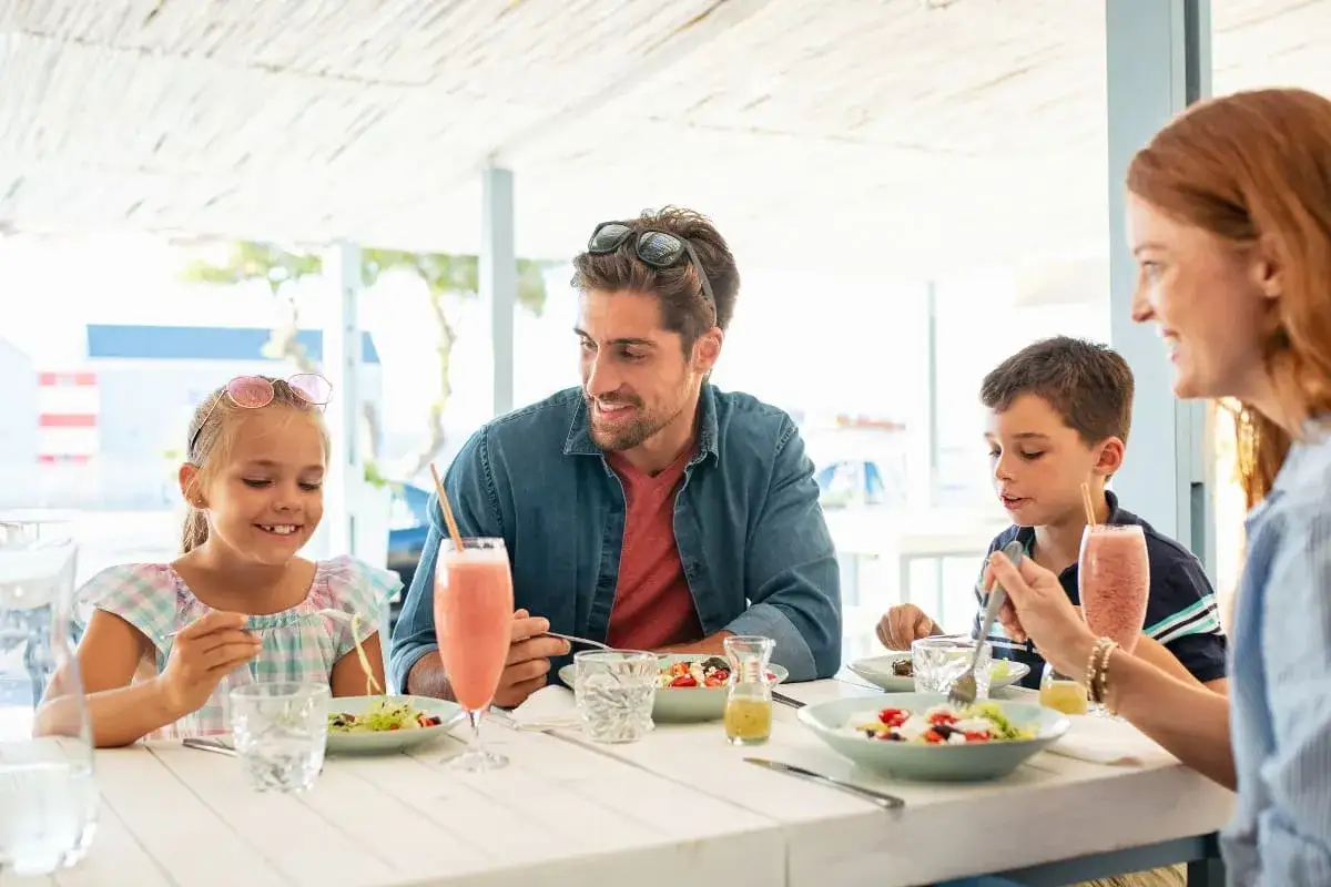 rodzina z dziećmi jedząca obiad w restauracji na wakacjach
