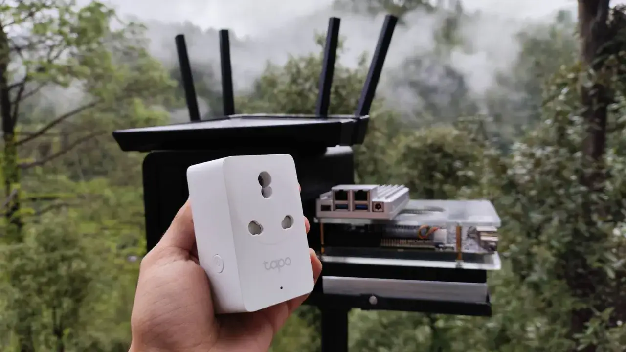 Inteligentne gniazdko Tapo w ręce, w tle router i Raspberry Pi. Rozwiązanie do monitorowania i sterowania urządzeniami, nawet gdy tuya smart poza siecią.