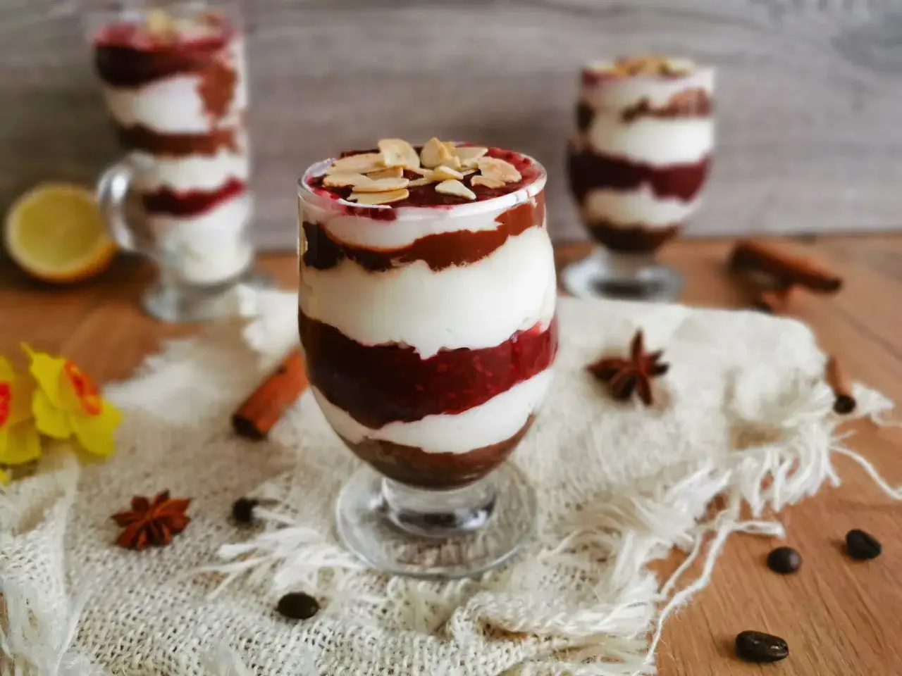 Pyszny deser z warstwami kremu i malinowej frużeliny, posypany płatkami migdałów. Idealny przepis na to, jak zrobić frużelinę z malin.