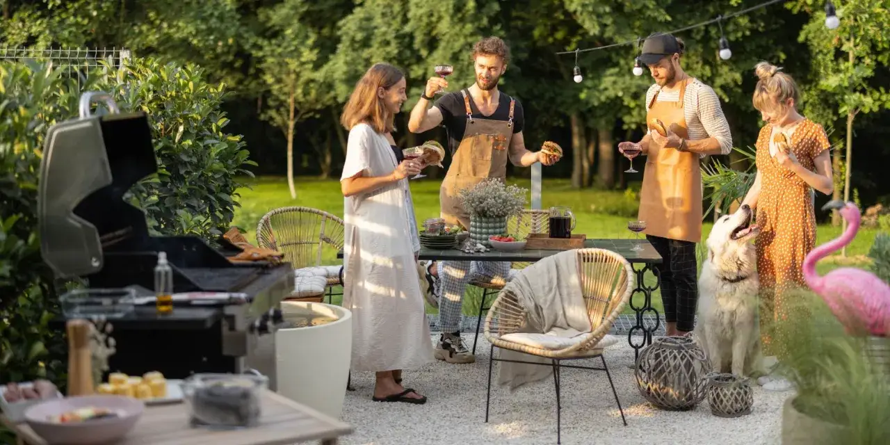 Przyjęcie w ogrodzie: ludzie z winem i burgerami, pies, grill i flaming.
