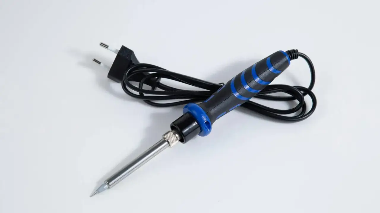 Lutownica do kabli z czarną rączką i niebieskimi wstawkami, gotowa do pracy.