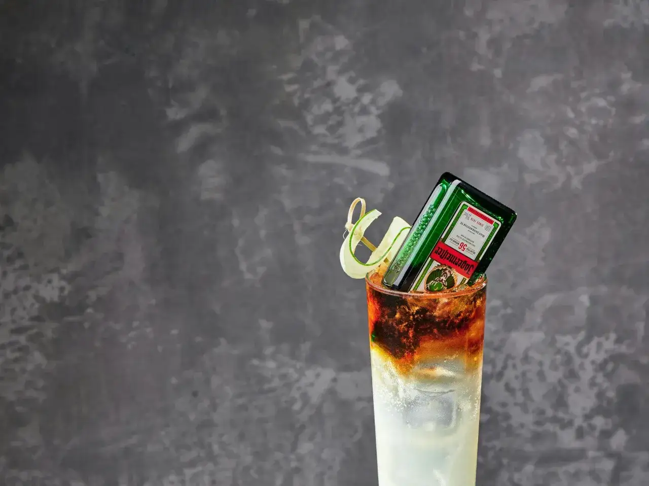 Jägermeister z czym pić? Ten drink z Jägermeisterem, lodem i plasterkiem ogórka wygląda orzeźwiająco.